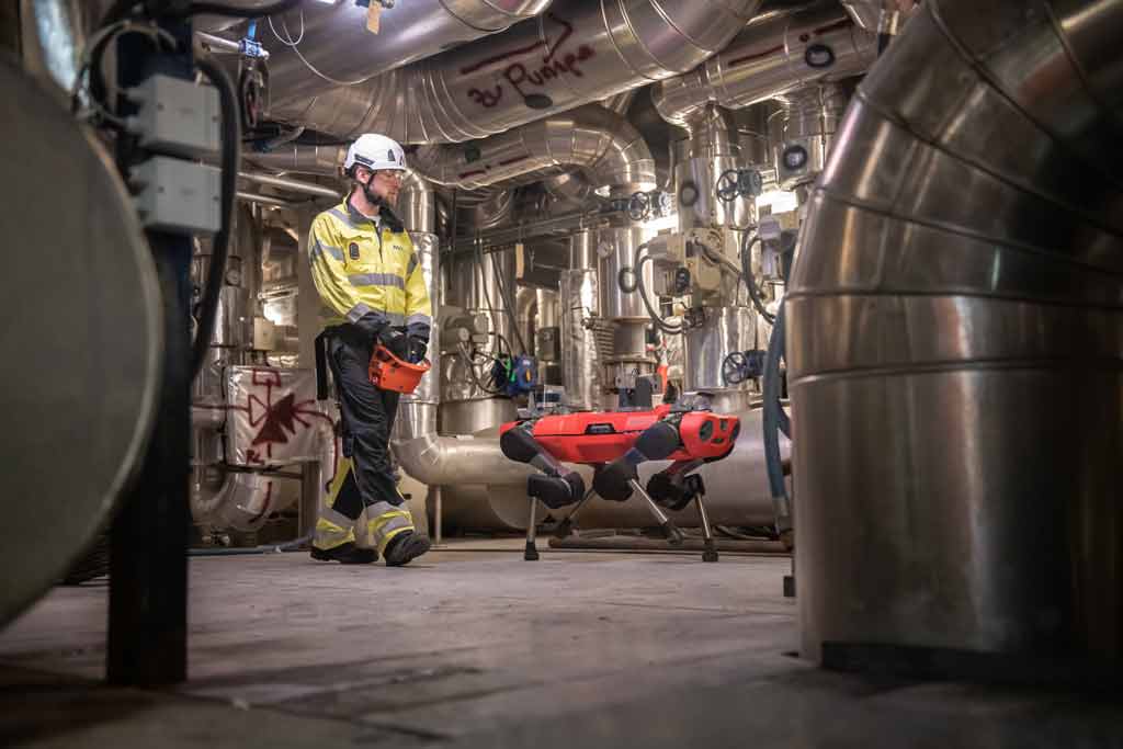 ANYmal C and human operator walk through industrial setting