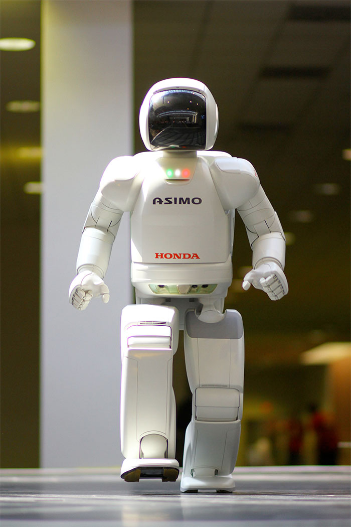 honda asimo robot walks across the stage.