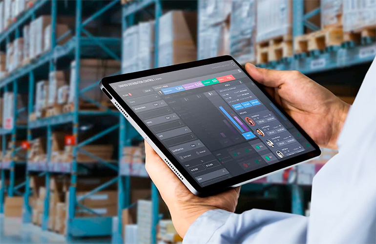man holding an ipad in a warehouse.