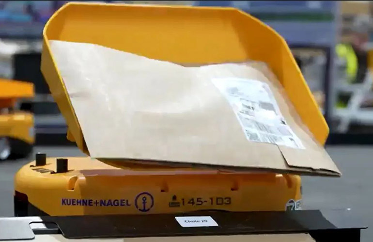 The Libiao mini yellow robot tilts items into the appropriate bin at Kuehne+Nagel.
