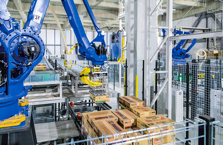 A blue robotic arm from Daifuku stacking boxes onto a pallet. The company provides ASRS for cold chain storage. 