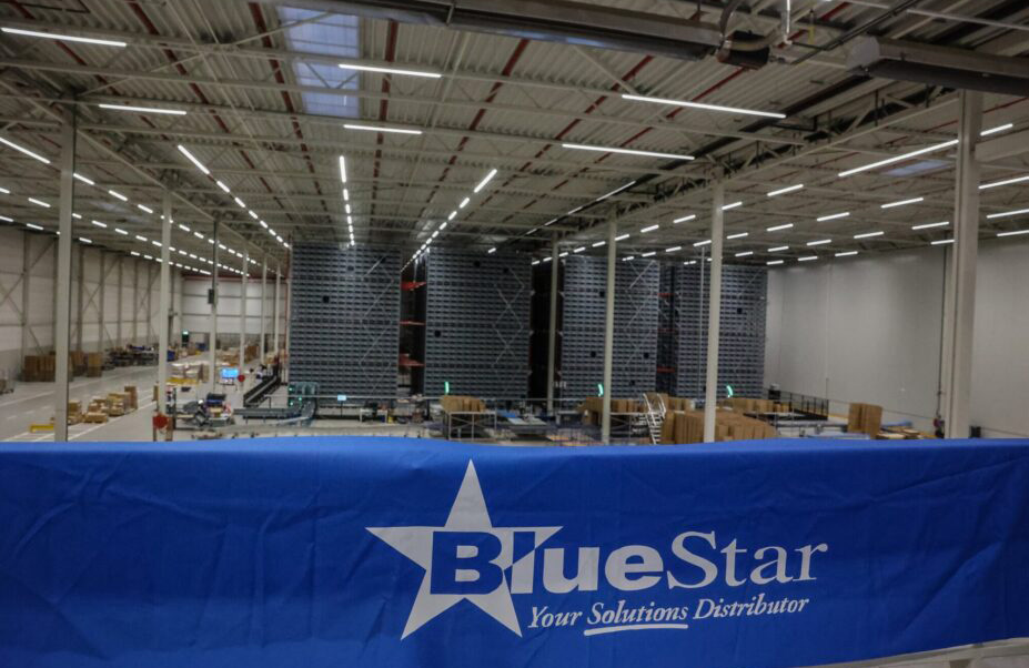 Exotec's Skypod ASRS system installed in a warehouse, with a blue BlueStar banner hanging in the foreground.