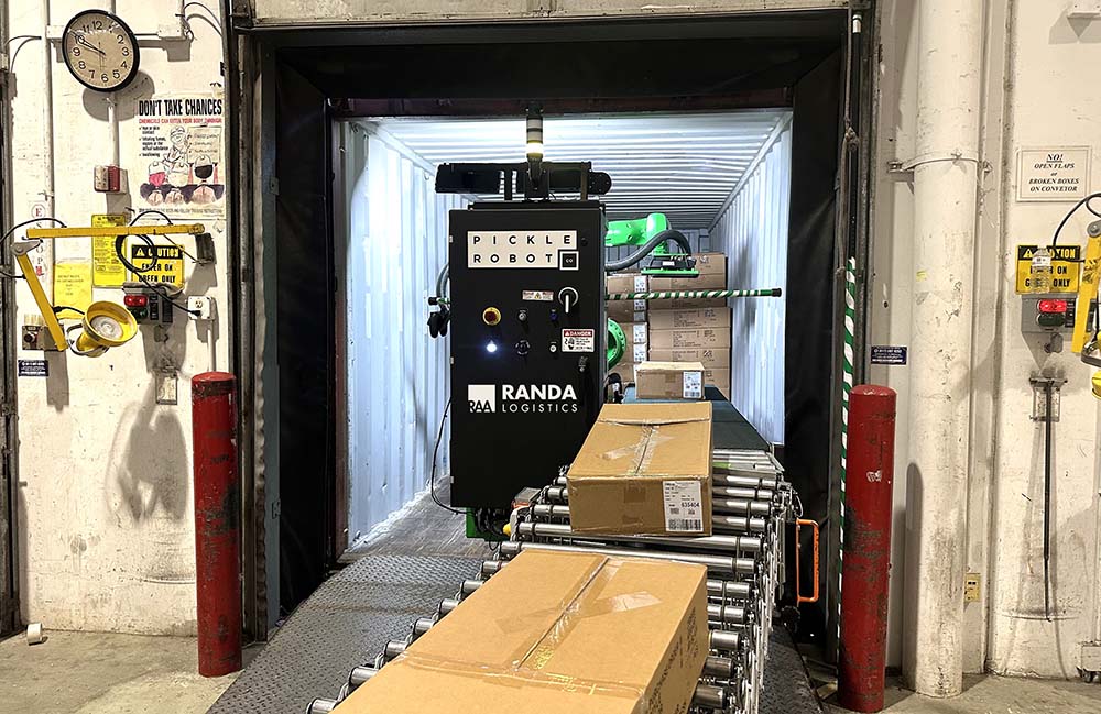 A green Pickle Robot operating in a container at Randa.