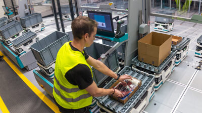 operator picks items from an exotec skypod amr.