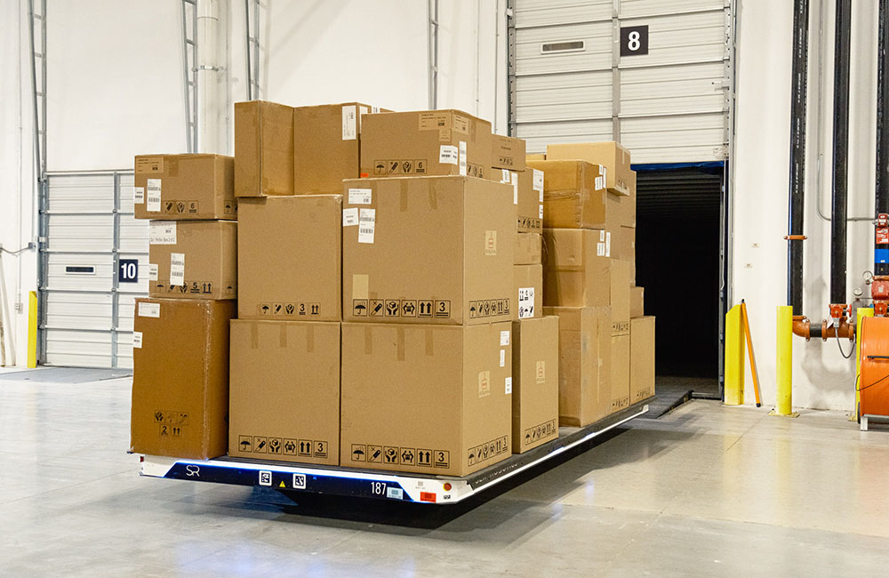A Slip Robotics SlipBot filled with boxes and leaving a truck bed. Furniture company Four Hands is using the system.