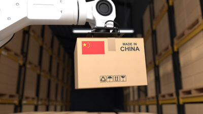 A robot arm picking up a cardboard box that has a Chinese flag and says "made in China."