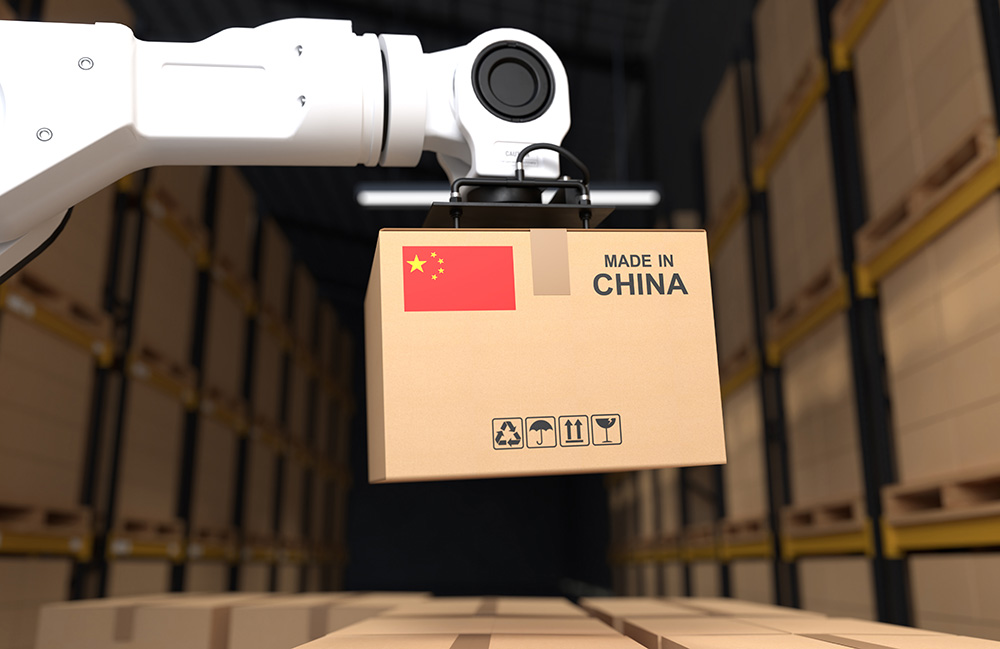 A robot arm picking up a cardboard box that has a Chinese flag and says "made in China."
