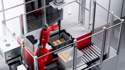 a six axis robot arm picks an item from a tote at a picking station.