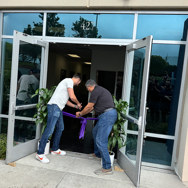 Mytra cofounder Chris Walti and Ahmad Baitalmal cut ribbon to new headquarters.