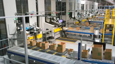 A warehouse featuring several collaborative robots filling boxes.