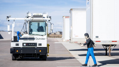 A diorama of a person walking in front of an Outrider truck.