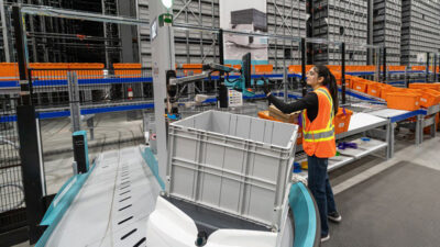Exotec's Skypod system, featuring a person at a picking station, in Amer Sports' order fulfillment operations.