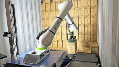 Anyware Robotics' Pixmo robot unloading a trailer to a conveyor.