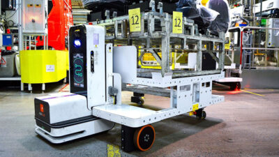Flexqube's AMRs carrying automotive parts in a customer facility.