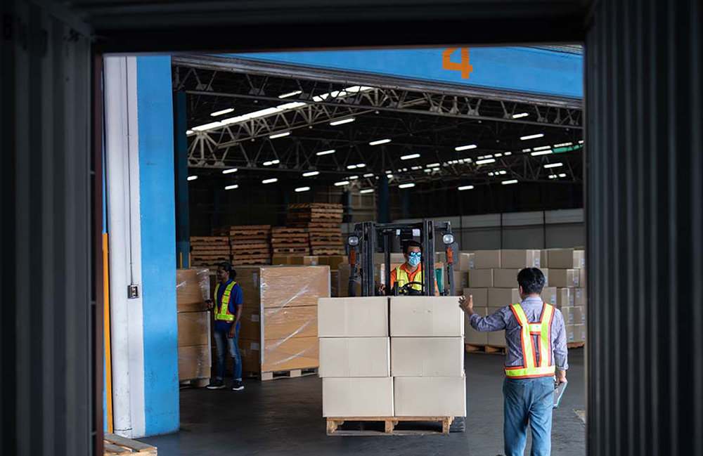 People moving a pallet of boxes through the Acceliot Smart Space Portal.